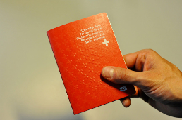 Une main tient le passeport suisse